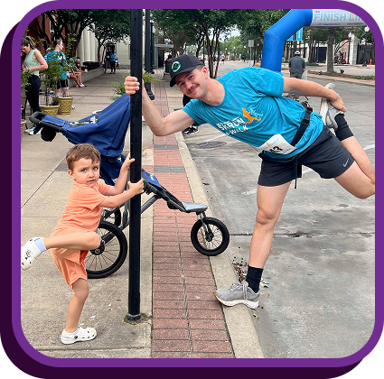 an adult and child pose at a race event